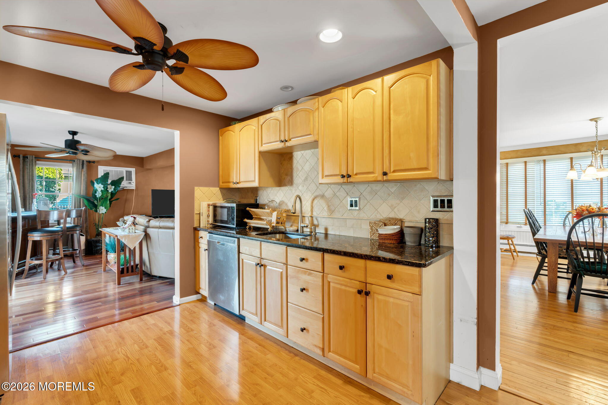 83 Seawood Drive Keyport, NJ 07735 - Photo 5 of 23 a kitchen with granite countertop a refrigerator a stove a sink a dining table and chairs with wooden floor