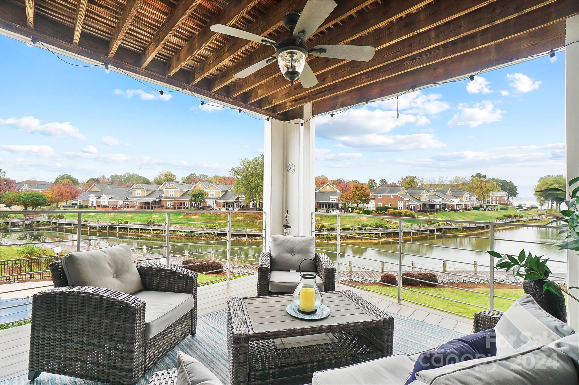 a view of swimming pool with lake view and couches in the patio