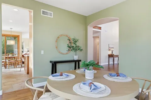 a kitchen with stainless steel appliances granite countertop wooden cabinets a dining table and chairs