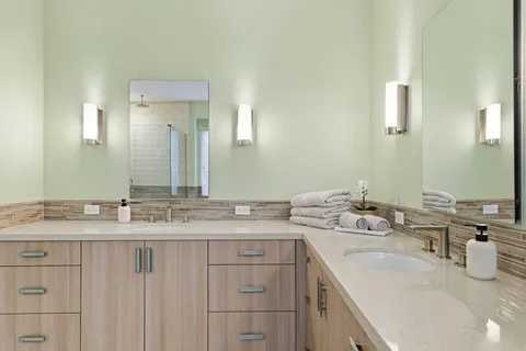 a bathroom with a shower sink vanity mirror and toilet