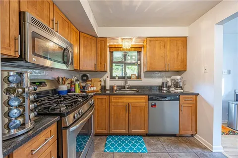 a kitchen with stainless steel appliances granite countertop a stove a sink and a microwave
