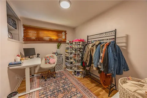 a walk in closet with clothes and shoes