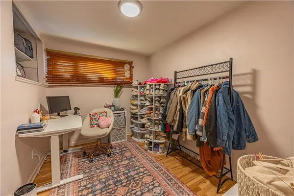 a walk in closet with clothes and shoes
