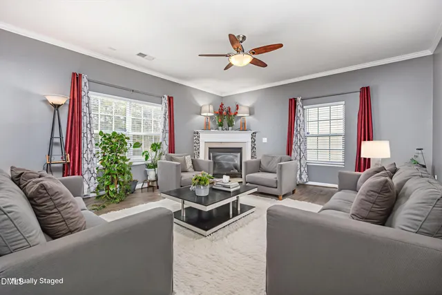 a living room with furniture fireplace and a large window