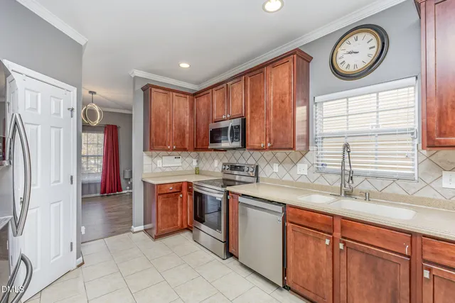 a kitchen with stainless steel appliances granite countertop a stove top oven a refrigerator and a sink