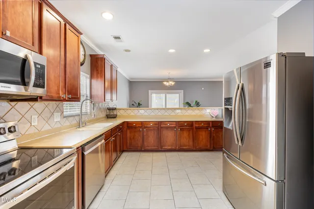 a kitchen with stainless steel appliances granite countertop a refrigerator and a sink