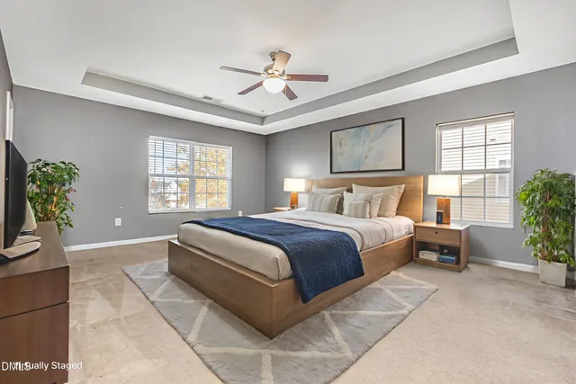 a bedroom with a large bed and windows