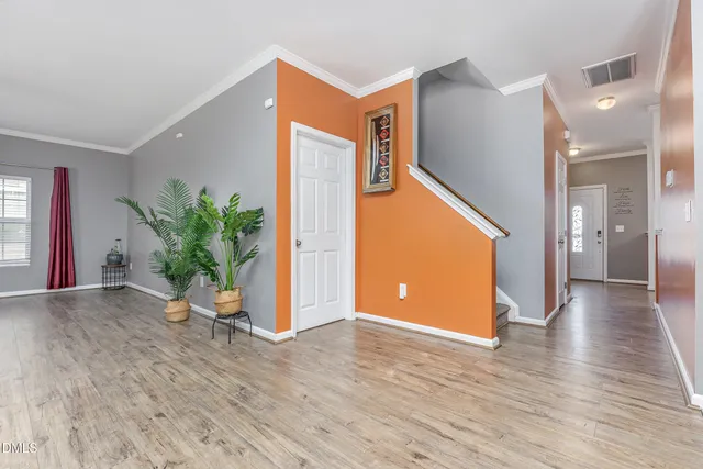a view of a hallway with wooden floor and a potted plant