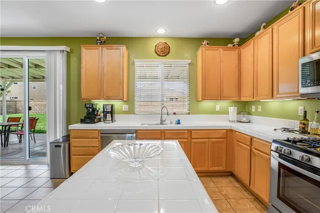 a large kitchen with a large window and stainless steel appliances