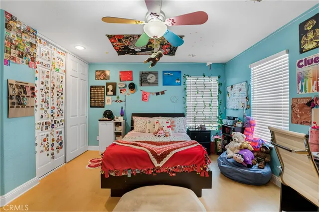 a bedroom with bed and ceiling fan