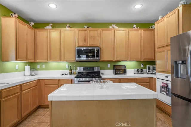 a kitchen with stainless steel appliances a stove a sink a microwave a refrigerator and cabinets