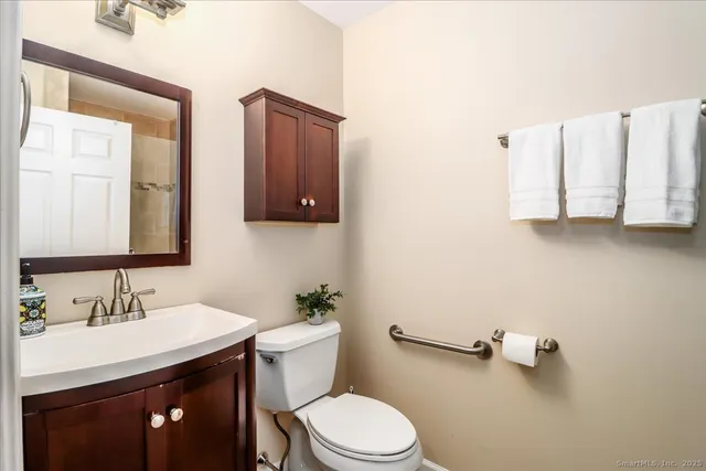 a bathroom with a sink vanity mirror and toilet