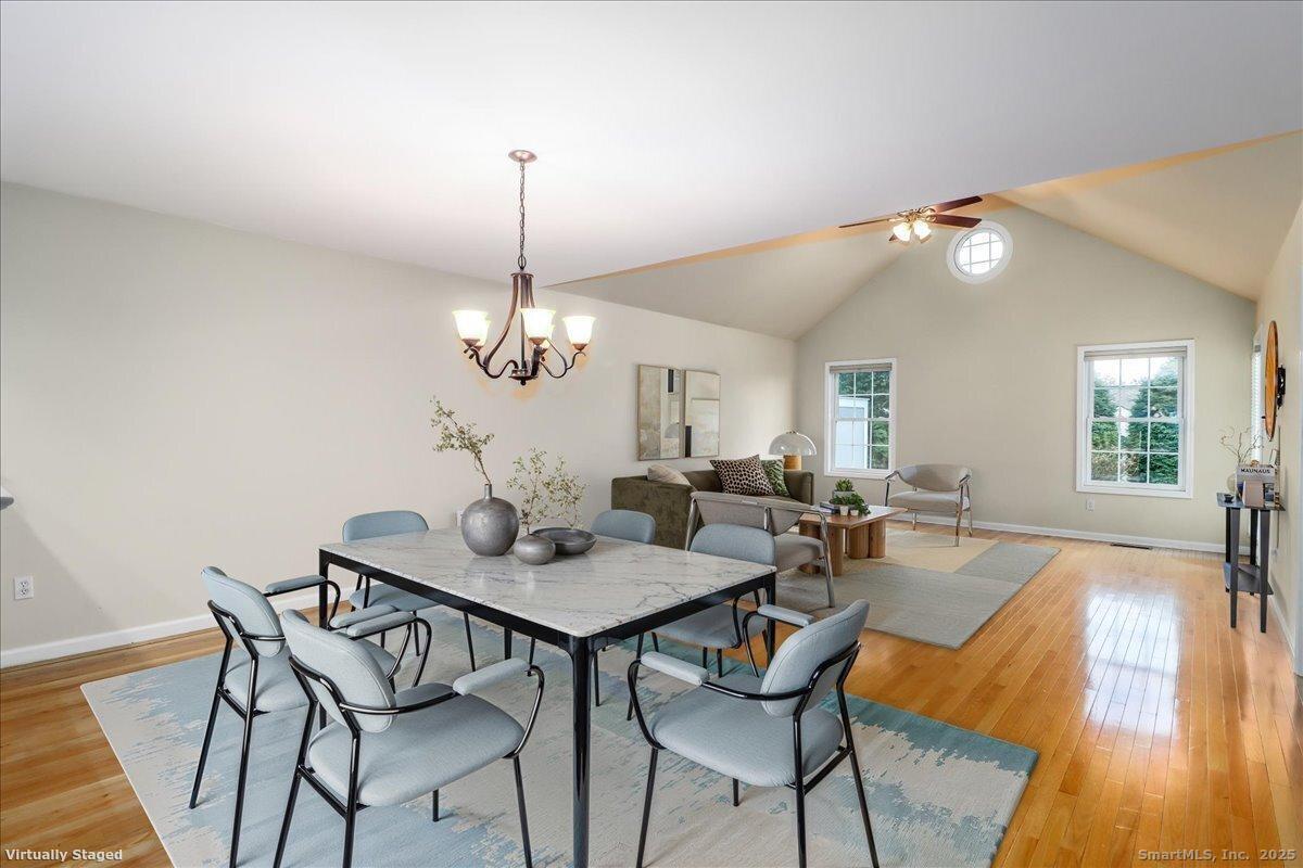 25 St George Place Newtown, CT 06482 - Photo 14 of 35 a dining room with furniture a chandelier and wooden floor