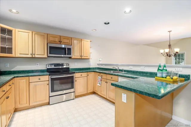a kitchen with stainless steel appliances granite countertop a sink stove and microwave