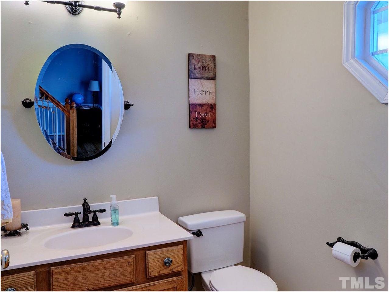 2312 Clerestory Place Raleigh, NC 27615 - Photo 11 of 25 a bathroom with a toilet a sink and mirror