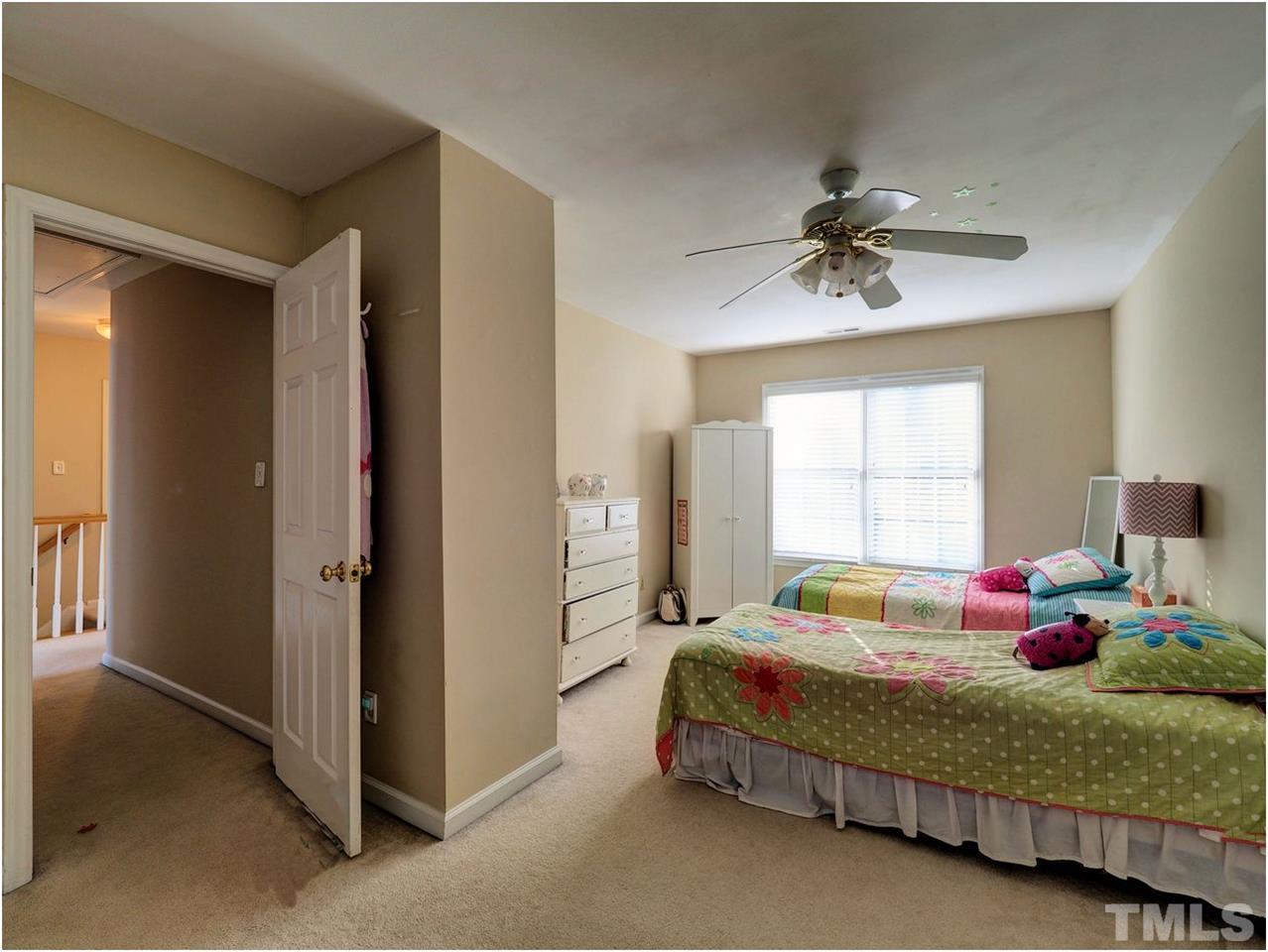 2312 Clerestory Place Raleigh, NC 27615 - Photo 19 of 25 a bedroom with a bed and a chandelier