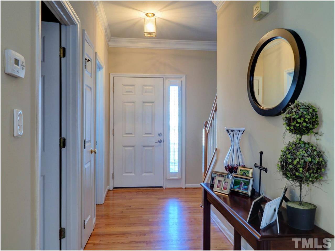 2312 Clerestory Place Raleigh, NC 27615 - Photo 5 of 25 a view of a hallway with entryway wooden floor and a mirror