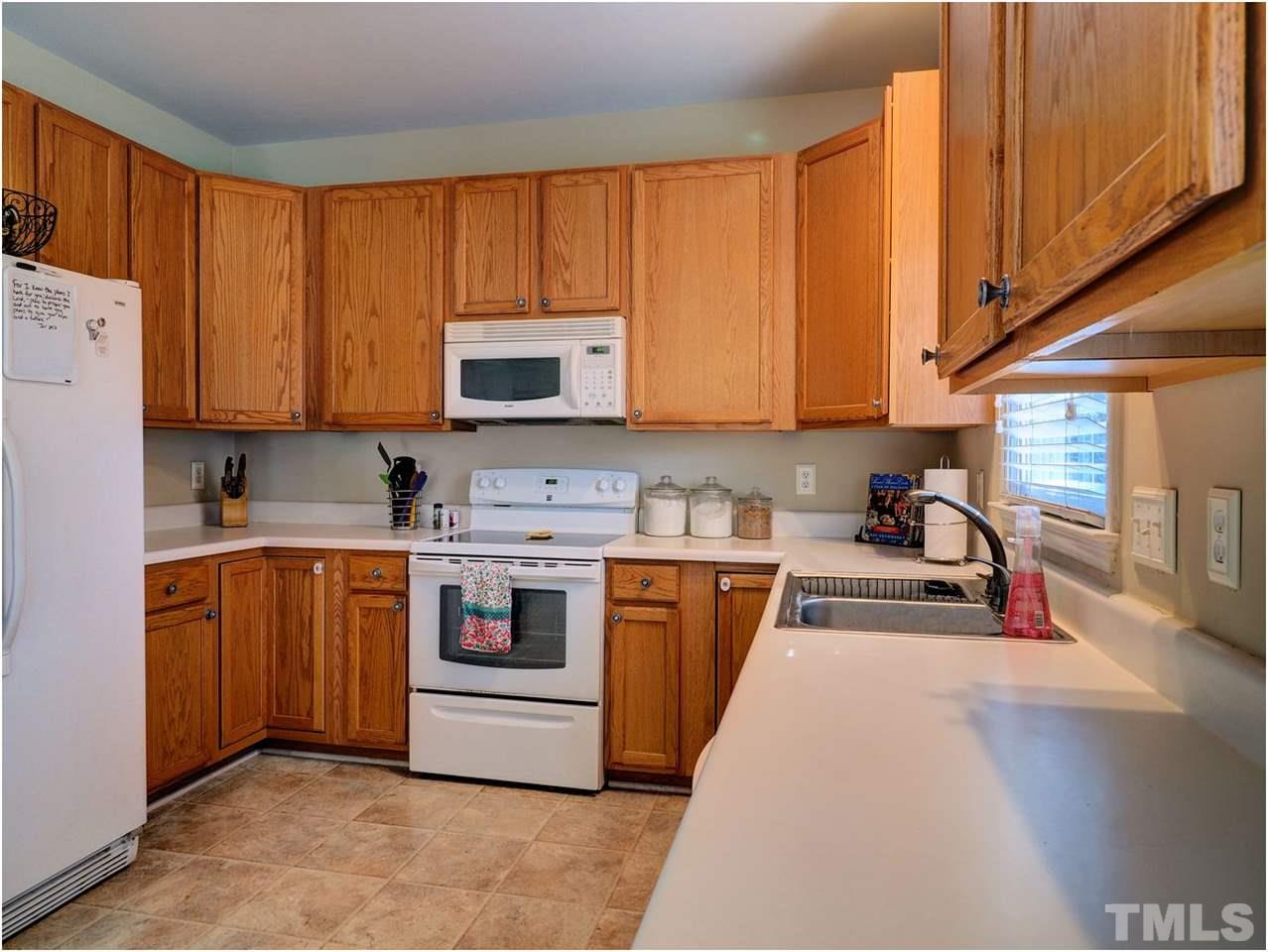 2312 Clerestory Place Raleigh, NC 27615 - Photo 6 of 25 a kitchen with stainless steel appliances granite countertop a stove a sink and a refrigerator