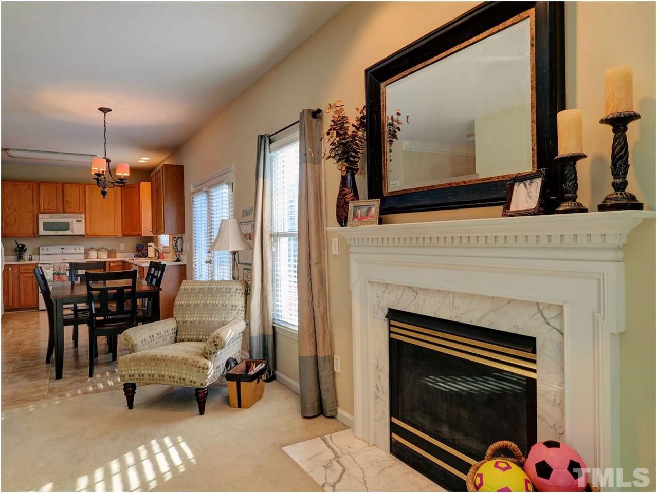 2312 Clerestory Place Raleigh, NC 27615 - Photo 9 of 25 a living room with furniture a fireplace and a flat screen tv