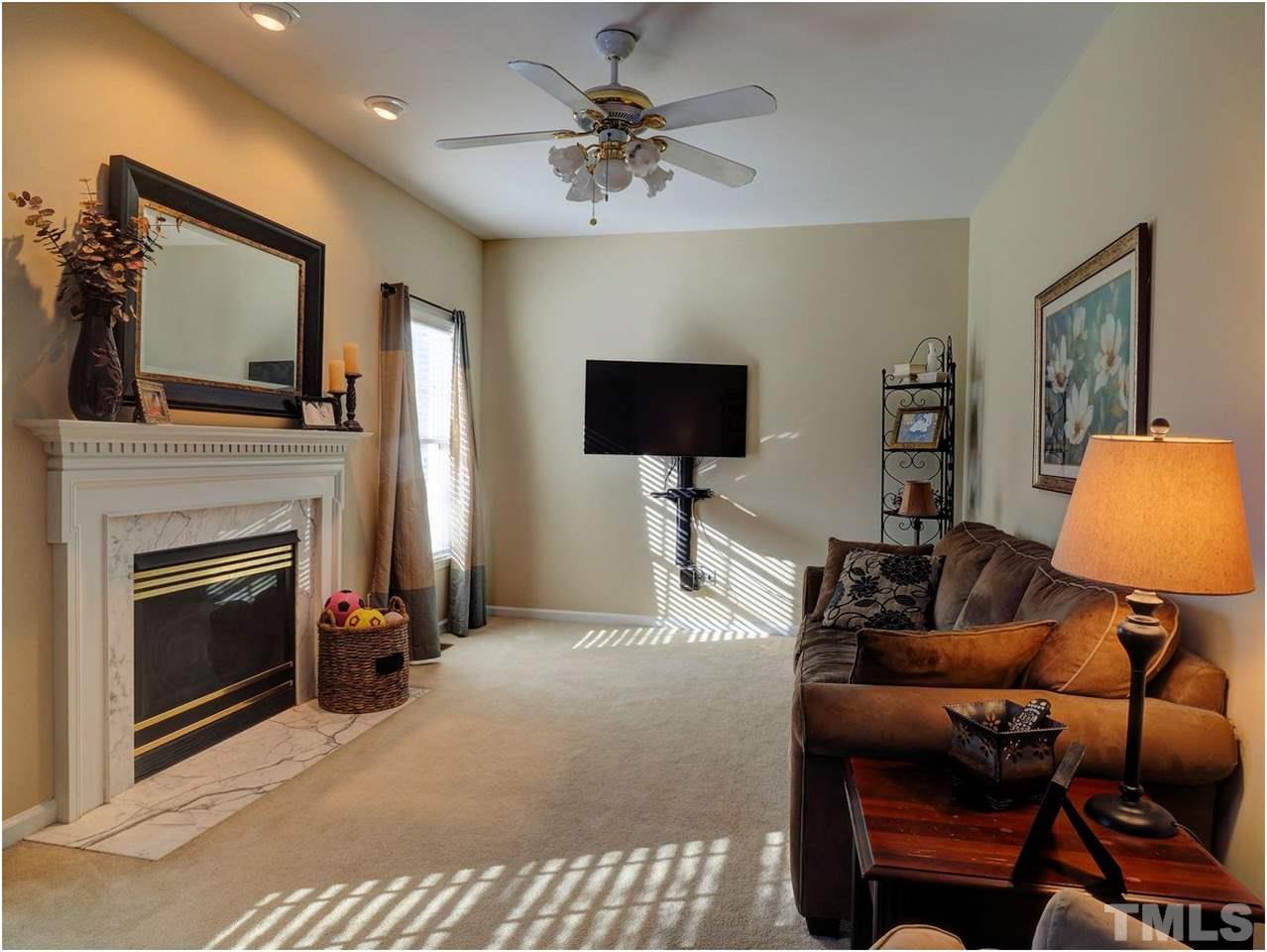 2312 Clerestory Place Raleigh, NC 27615 - Photo 10 of 25 a living room with furniture a flat screen tv and a fireplace