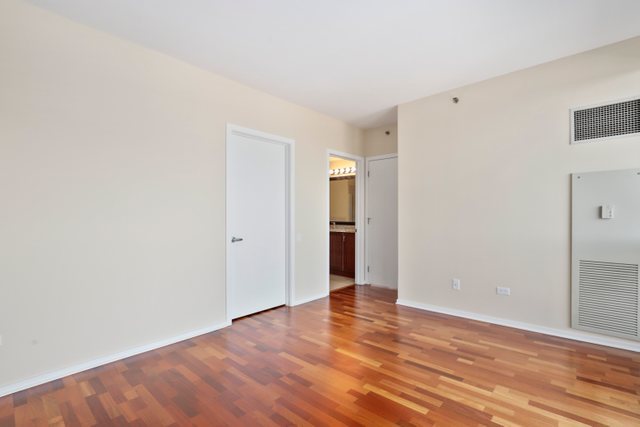 210 South Desplaines Street, Unit 2002 Chicago, IL 60661 - Photo 13 of 24 a view of an empty room with wooden floor and closet