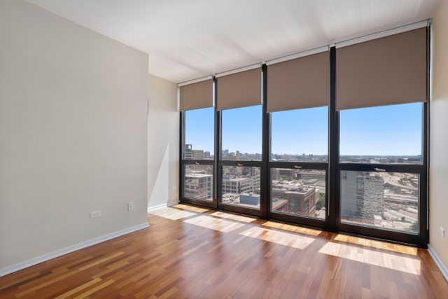 210 South Desplaines Street, Unit 2002 Chicago, IL 60661 - Photo 16 of 24 wooden floor in an empty room with windows