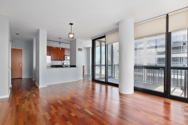 210 South Desplaines Street, Unit 2002 Chicago, IL 60661 - Photo 5 of 24 a view of a big room with wooden floor and a kitchen