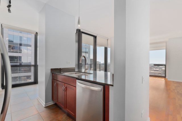 210 South Desplaines Street, Unit 2002 Chicago, IL 60661 - Photo 7 of 24 a kitchen with stainless steel appliances granite countertop a stove and a refrigerator