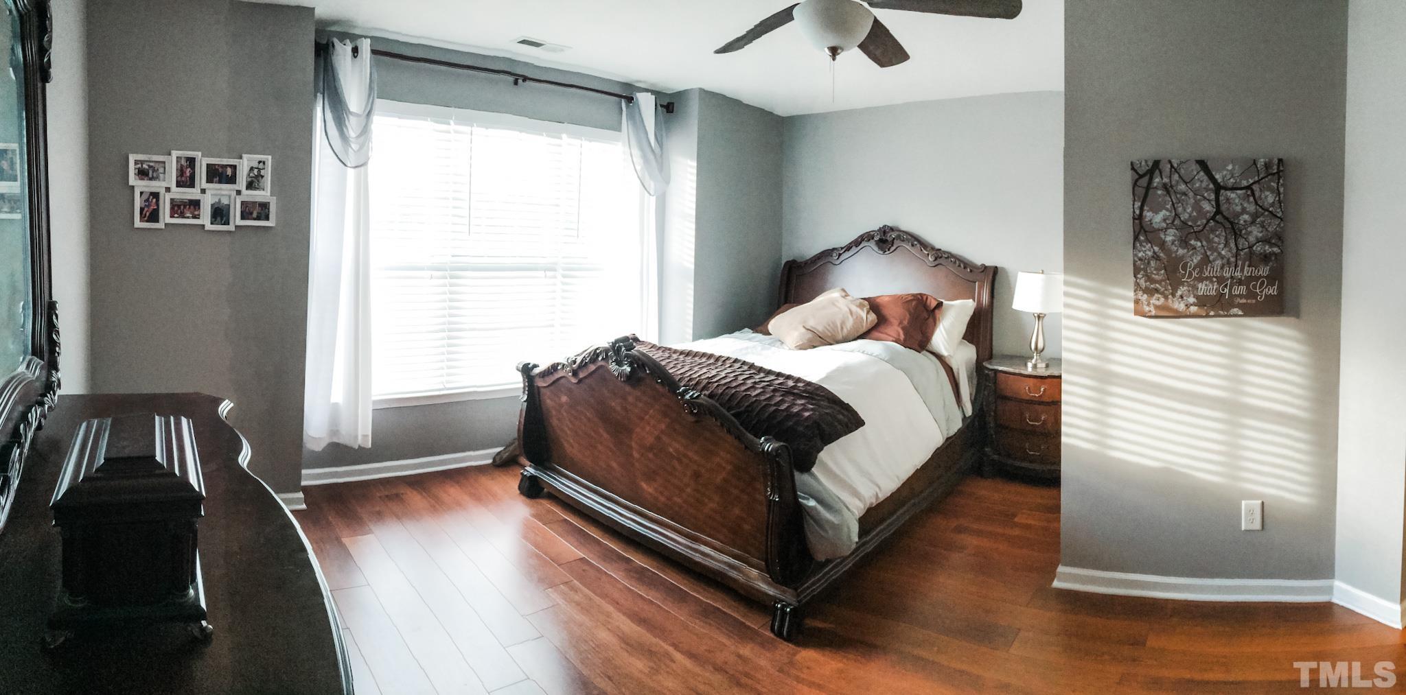9906 Marni Court Raleigh, NC 27617 - Photo 9 of 11 a bedroom with a bed and wooden floor