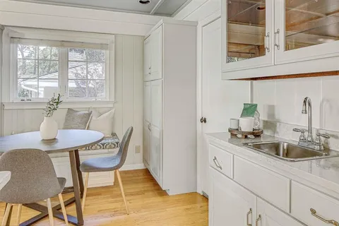 a kitchen with stainless steel appliances a sink a table and chairs