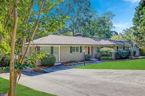 a front view of a house with a garden and plants