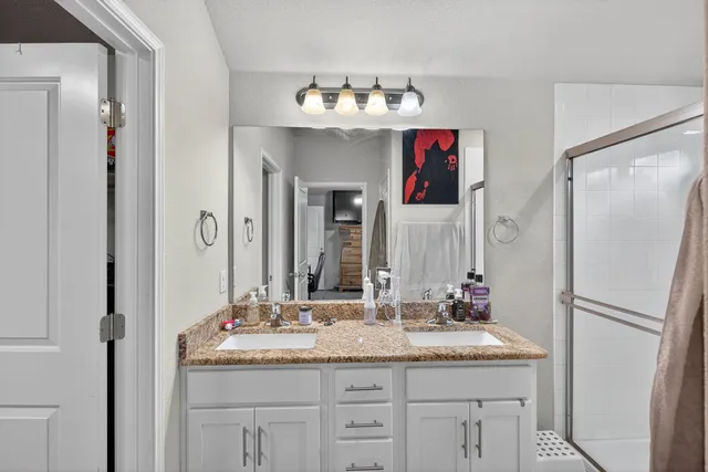 a bathroom with a granite countertop shower sink and mirror