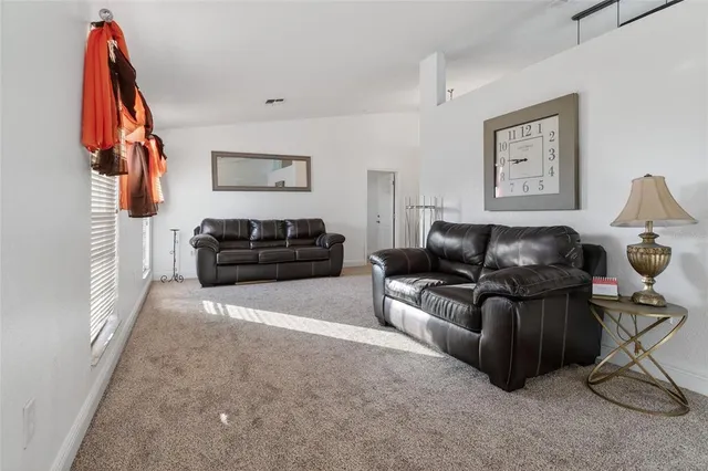 a living room with furniture a clock and a window