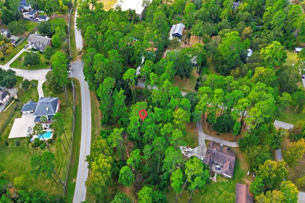 an aerial view of residential house with outdoor space and trees all around