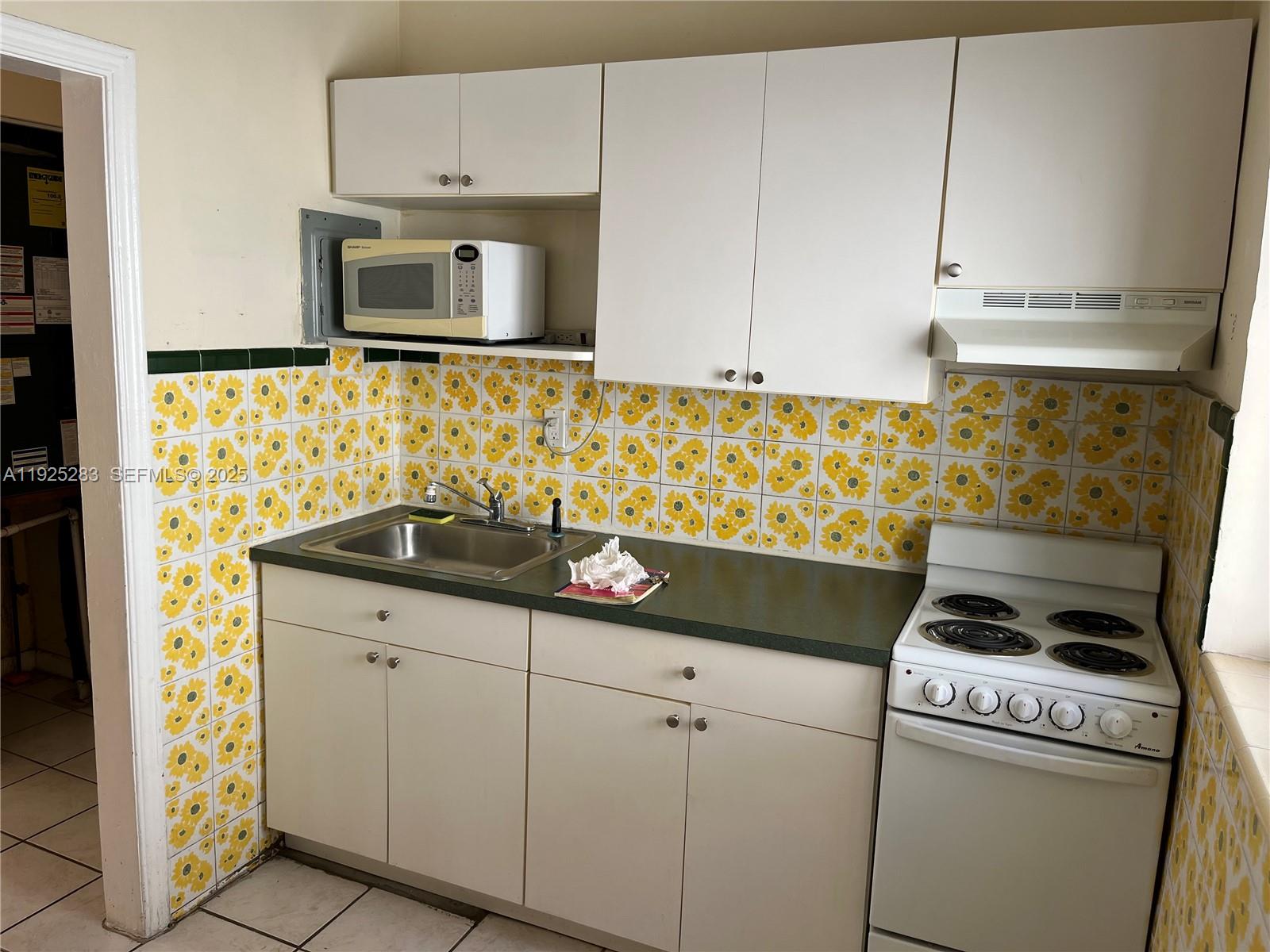 1035 Southwest 3rd Street, Unit 2 Miami, FL 33130 - Photo 11 of 13 a kitchen with sink stove and cabinets