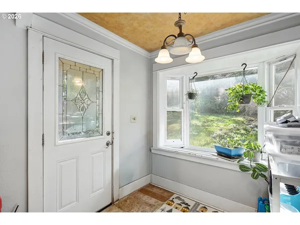 a view of a hallway with wooden floor and a dining table
