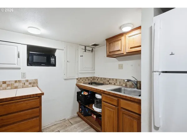 a kitchen with a sink and a stove top oven with wooden floor