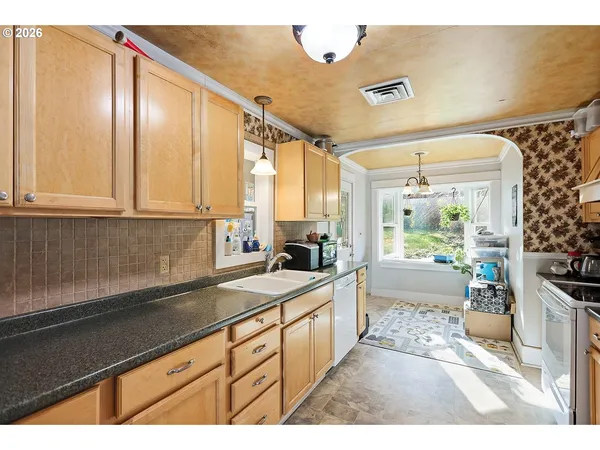 a kitchen with stainless steel appliances granite countertop a sink stove and cabinets