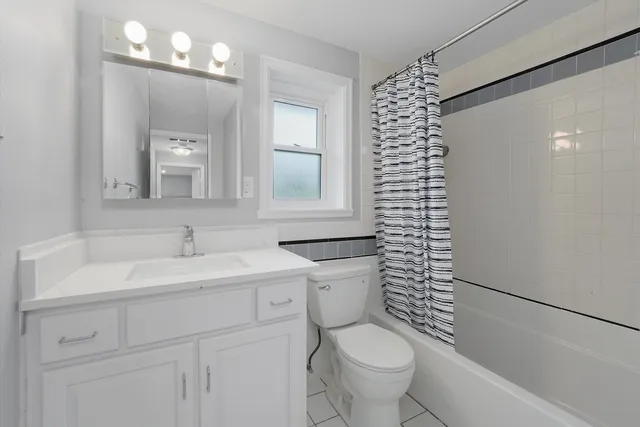 a bathroom with a sink a toilet a mirror a vanity and shower