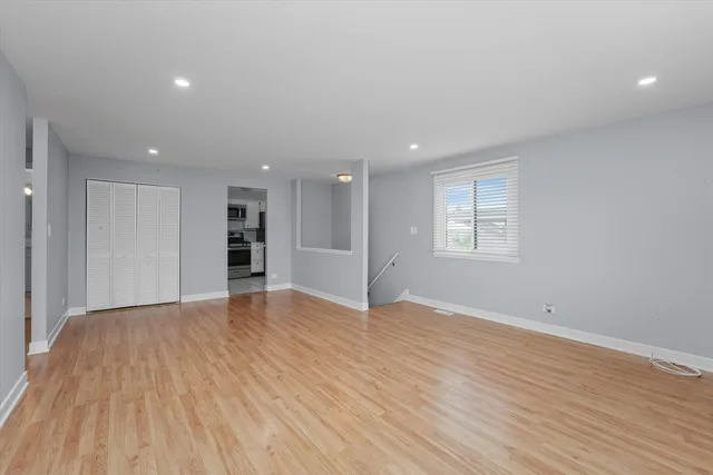 a view of empty room with wooden floor and window