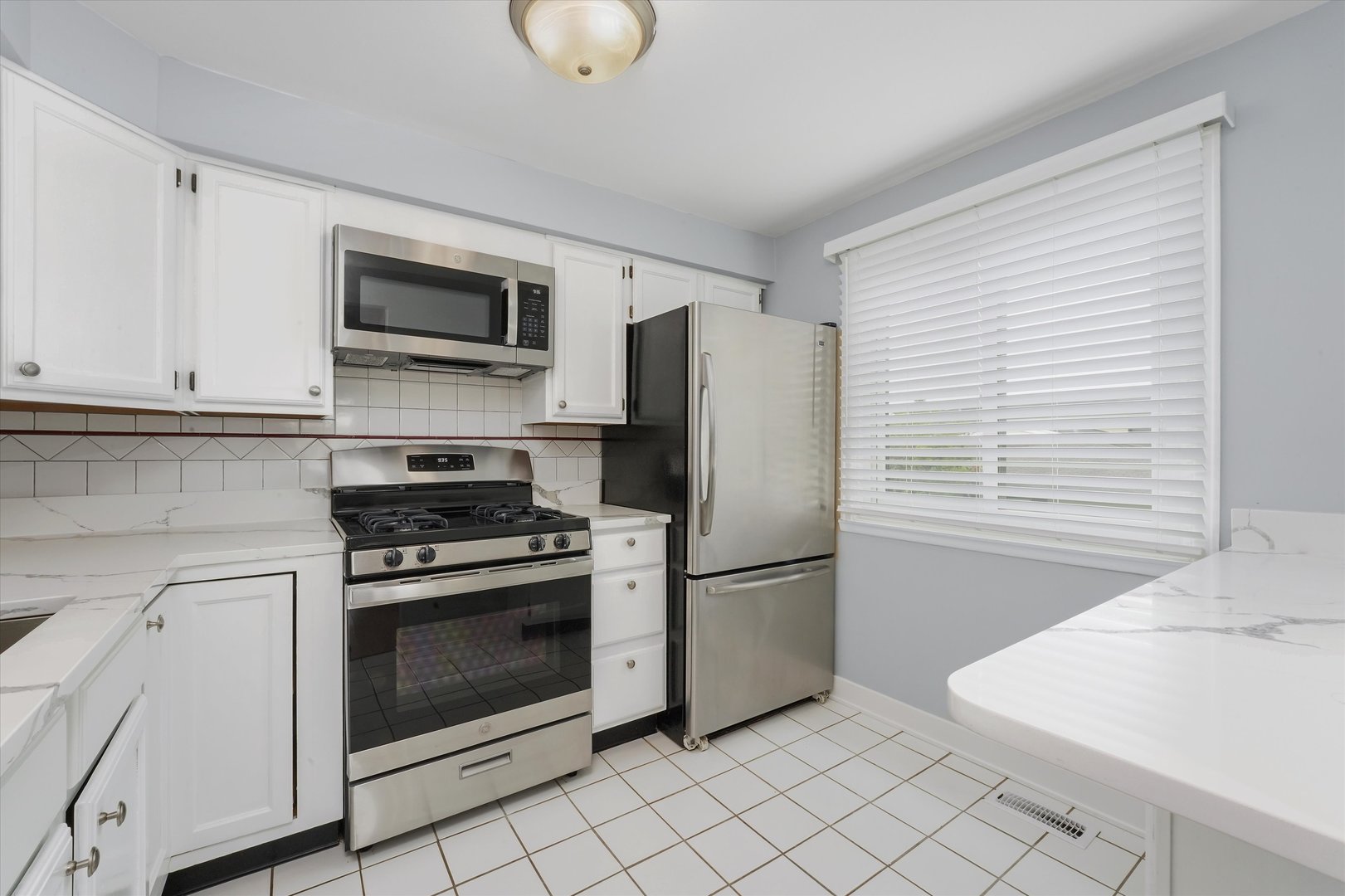 1323 Wakeby Lane, Unit 1323 Schaumburg, IL 60193 - Photo 6 of 14 a kitchen with stainless steel appliances granite countertop a refrigerator and a stove top oven