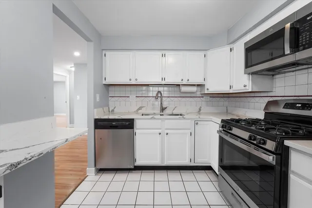 a kitchen with stainless steel appliances a sink dishwasher stove top oven and cabinets