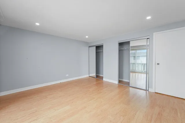 a view of an empty room with wooden floor and entryway