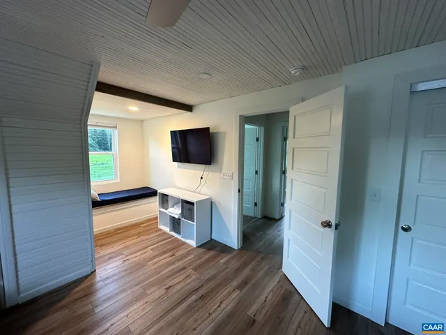 a view of a livingroom with wooden floor and a flat screen tv