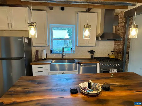 a kitchen with kitchen island granite countertop wooden cabinets and a refrigerator