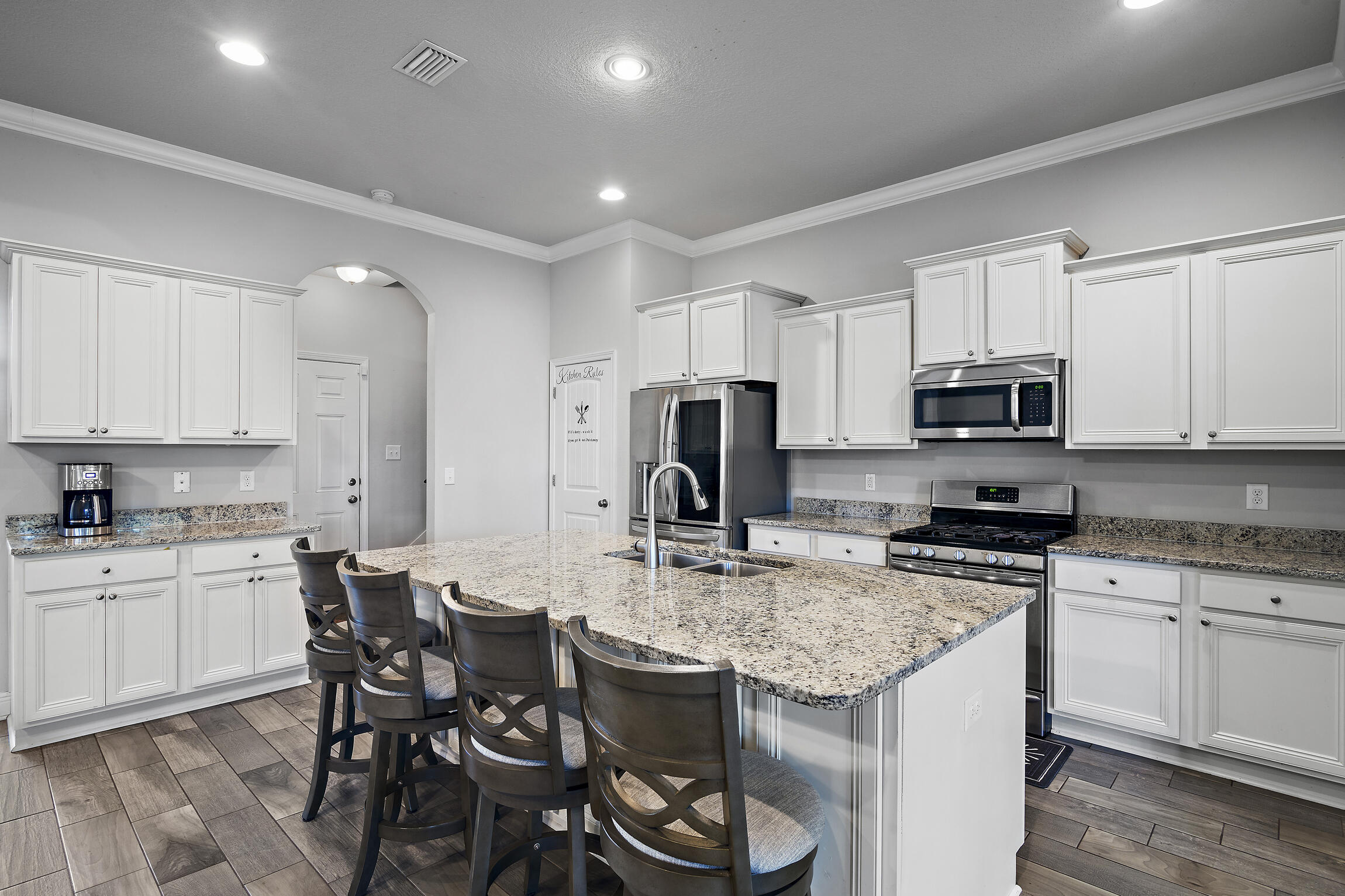 369 Lilly Bell Lane Freeport, FL 32439 - Photo 6 of 24 a kitchen with kitchen island granite countertop a sink stove and white cabinets