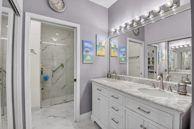 a bathroom with a granite countertop sink a mirror and a shower