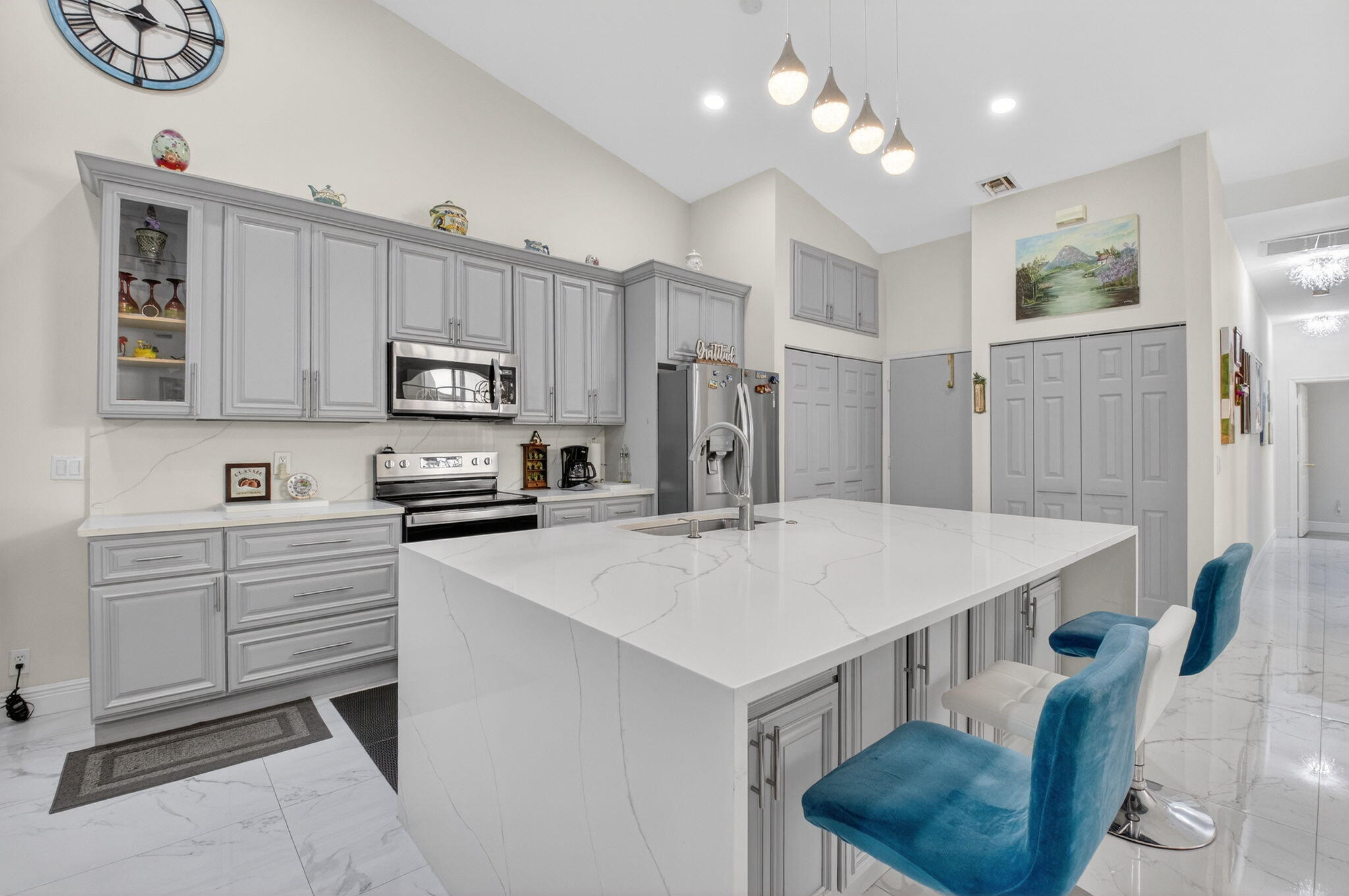6247 Heliconia Road Delray Beach, FL 33484 - Photo 5 of 25 a kitchen with kitchen island a stove a table and chairs in it