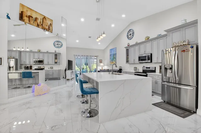 a kitchen with cabinets and chairs