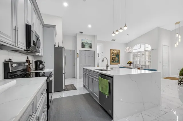 a kitchen with stainless steel appliances a sink stove and refrigerator